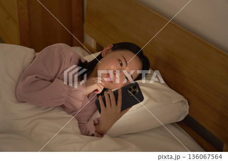 布団の中でスマホを使う女性 布団の中でスマホを使う女性 136067564