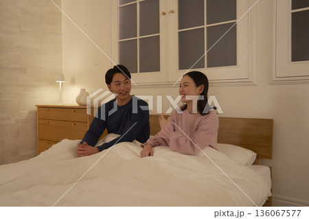 ベッドの上で会話する夫婦 ベッドの上で会話する夫婦 136067577