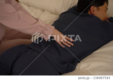 ベッドの上で夫をマッサージする妻　クローズアップ 136067583