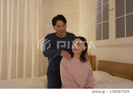 寝室で妻の肩揉みをする夫 136067585