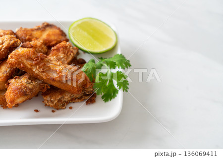 Fried Snapper Belly on white plate 136069411