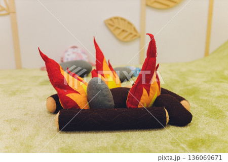 Small felt fire scene with glowing flames, Miniature felted campfire surrounded by stones and logs, Delicate handcrafted felt campfire with bright flames and soft surroundings 136069671