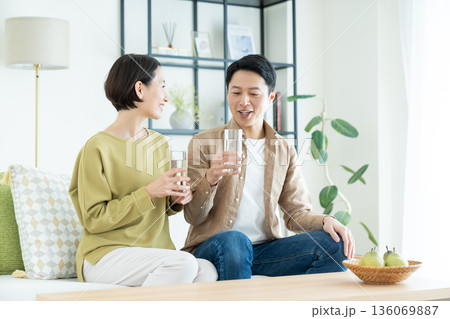 ミネラルウォーターを飲むミドルの夫婦 136069887