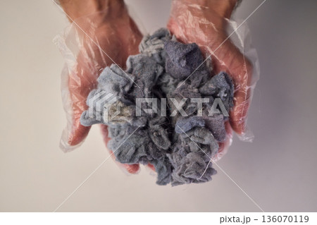 Detailed scene showing lint and cleaning, Warm indoor shot of hands clearing dryer lint, Closeup capturing hands inspecting fluffy lint fibers from machine filter 136070119