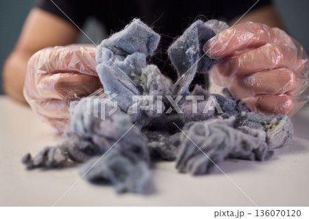 Detailed scene showing lint and cleaning, Warm indoor shot of hands clearing dryer lint, Closeup capturing hands inspecting fluffy lint fibers from machine filter Detailed scene showing lint and cleaning, Warm indoor shot of hands clearing dryer lint, Closeup capturing hands inspecting fluffy lint fibers from machine filter 136070120