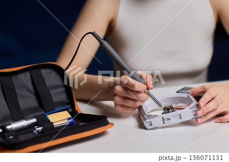 Precise fan motor wiring craft, Closeup of careful electrical soldering work, Meticulous assembly of fan motor components through precision soldering and careful alignment 136071131