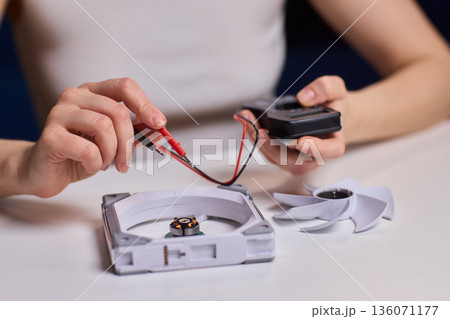 Meticulous technician conducts detailed inspection of fan wiring connectivity, Focused technician meticulously tests and inspects fan motor connections with precision and care 136071177