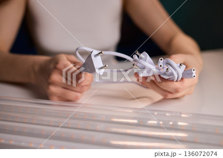 Hands connecting cable, Cable connection during hydroponic system maintenance, Closeup of technician aligning power plug for efficient indoor agricultural lighting system Hands connecting cable, Cable connection during hydroponic system maintenance, Closeup of technician aligning power plug for efficient indoor agricultural lighting system 136072074