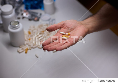 Anxious scene showing medication overload and health concerns, Clinical setting depicting patient holding pills surrounded by bottles indicating potential overdose Anxious scene showing medication overload and health concerns, Clinical setting depicting patient holding pills surrounded by bottles indicating potential overdose 136073620