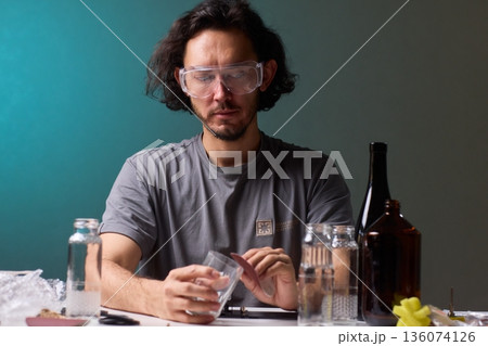 Safety Equipment Used During Glass Cutting, Workstation Setup for Safe Glass Shaping Procedure, Background of Workshop with Focus on Cutting Tools and Safety Precautions 136074126