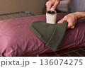 Close view of lint tool on wool, Man using lint roller to clean wool hat texture, Detailed scene of hand grooming fuzz from soft knitted wool hat with lint roller 136074275