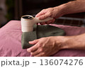 Close view of lint tool on wool, Man using lint roller to clean wool hat texture, Detailed scene of hand grooming fuzz from soft knitted wool hat with lint roller 136074276