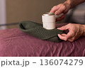 Close view of lint tool on wool, Man using lint roller to clean wool hat texture, Detailed scene of hand grooming fuzz from soft knitted wool hat with lint roller 136074279