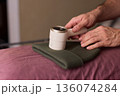 Close view of lint tool on wool, Man using lint roller to clean wool hat texture, Detailed scene of hand grooming fuzz from soft knitted wool hat with lint roller 136074284