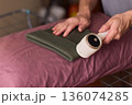 Close view of lint tool on wool, Man using lint roller to clean wool hat texture, Detailed scene of hand grooming fuzz from soft knitted wool hat with lint roller 136074285