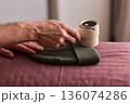 Close view of lint tool on wool, Man using lint roller to clean wool hat texture, Detailed scene of hand grooming fuzz from soft knitted wool hat with lint roller 136074286