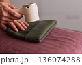 Close view of lint tool on wool, Man using lint roller to clean wool hat texture, Detailed scene of hand grooming fuzz from soft knitted wool hat with lint roller 136074288