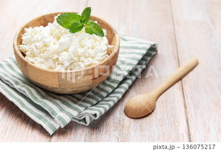 Cottage cheese in wooden bowl with mint on rustic table Cottage cheese in wooden bowl with mint on rustic table 136075217