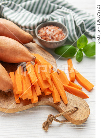 Preparing sweet potato fries on a cutting board 136075221