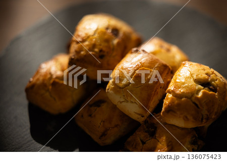 窓からの自然光に照らされた黒いプレートのスコーン 窓からの自然光に照らされた黒いプレートのスコーン 136075423