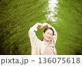 新緑のメタセコイヤ並木道で笑顔の女性 136075618
