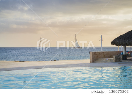 Two sailboats are racing through the Caribbean sea during sunset 136075802