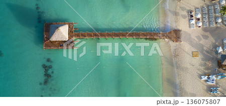 Top view of a small hut on a wooden pier on Bayahibe beach with turquoise water 136075807