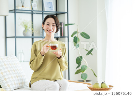 リビングで紅茶を飲むミドルの女性 136076140