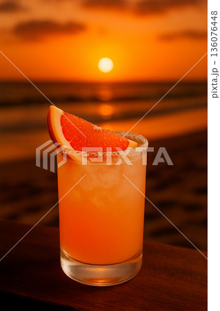 夕日輝くビーチで楽しむグレープフルーツを添えたパロマカクテル 136076448