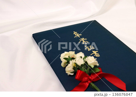 白い薔薇の花束と紺色の卒業証書ホルダー 136076847