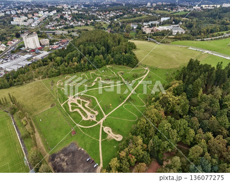 Expansive Aerial Scene Showcasing Sculpted Pathways Amidst Vibrant Countryside And Forested Zones 136077275