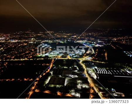 Urban Factory Area Illuminated Beneath Cloudy Sky With Organized Grid And Bustling Activity Urban Factory Area Illuminated Beneath Cloudy Sky With Organized Grid And Bustling Activity 136077323
