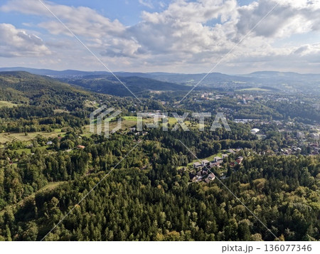 Scene Depicting Natural Greenery Transitioning Into Urban Development Beneath Layered Cloud Formations Scene Depicting Natural Greenery Transitioning Into Urban Development Beneath Layered Cloud Formations 136077346