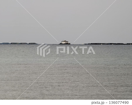 Solitary shelter scene, Quiet retreat by sea featuring small shelter beneath muted sky and still waters Solitary shelter scene, Quiet retreat by sea featuring small shelter beneath muted sky and still waters 136077490