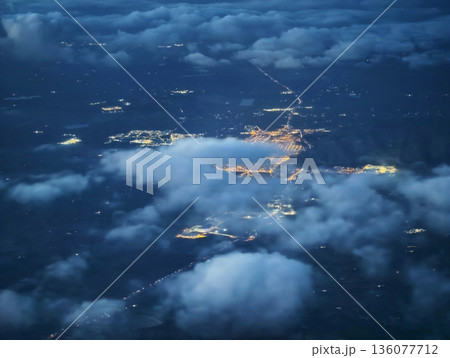 Bright city lights outshine fog, Colorful city illumination exceeds dimness of cloudy atmospheric views Bright city lights outshine fog, Colorful city illumination exceeds dimness of cloudy atmospheric views 136077712