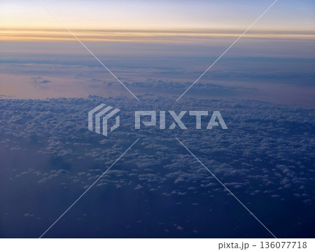 Broad cloud formation extends towards horizon with subtle twilight hues and surface details Broad cloud formation extends towards horizon with subtle twilight hues and surface details 136077718