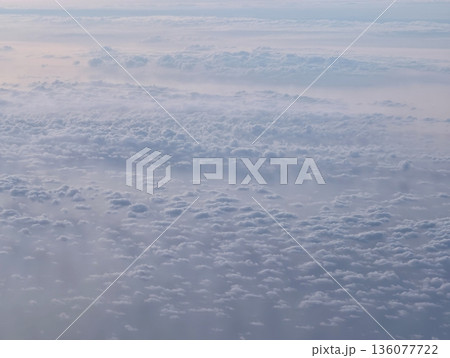 Aerial view sunrise clouds over sea with warm pastel glow and distant horizon travel blogger perspective 136077722