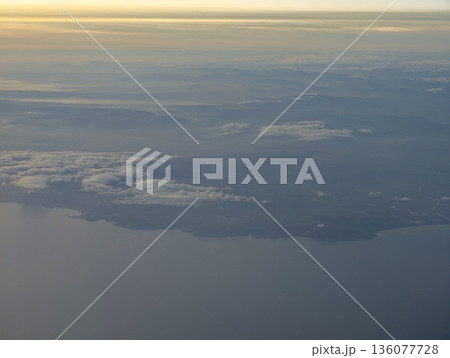 Peaceful turquoise shoreline from above, Elevated image showcasing serene azure waters and drifting clouds 136077728