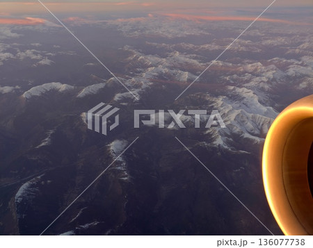 Sunset illumination on aircraft parts, Sunset reflecting off aircraft engine above mountain range 136077738