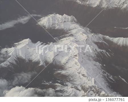 Mountain snow peaks, Snowy mountain peaks from above, Aerial shot of icy rugged mountain formations 136077761