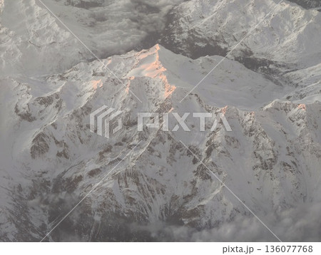 Sunrise peak with rugged terrain, Early morning summit scene with pink hues on rugged mountain features 136077768