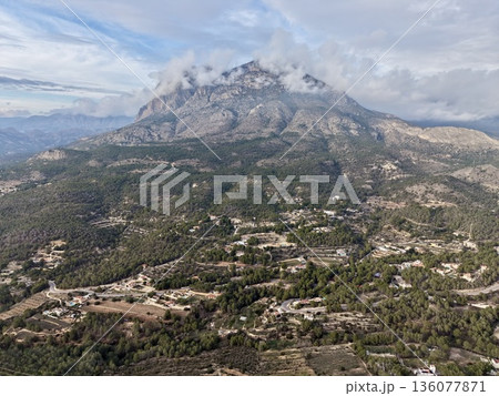 Stunning view of mountain massifs displaying intricate rock layers and surrounding inhabited areas 136077871