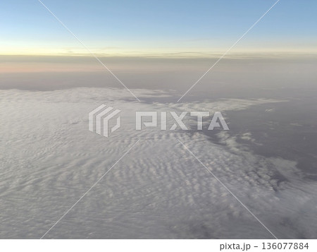 Aerial perspective capturing tranquil ocean and layered clouds at sunrise in soft pastel shades Aerial perspective capturing tranquil ocean and layered clouds at sunrise in soft pastel shades 136077884