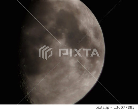 Closeup shot of waxing moon illustrates deep shadows and rugged landscape in stark contrast 136077893