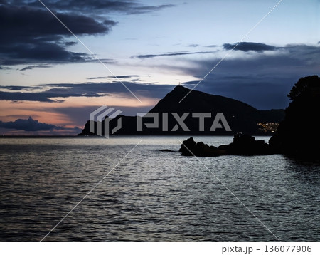 Evening serene view, Calm bay under cloudy sky, Peaceful sunset scene with ocean and silhouettes Evening serene view, Calm bay under cloudy sky, Peaceful sunset scene with ocean and silhouettes 136077906