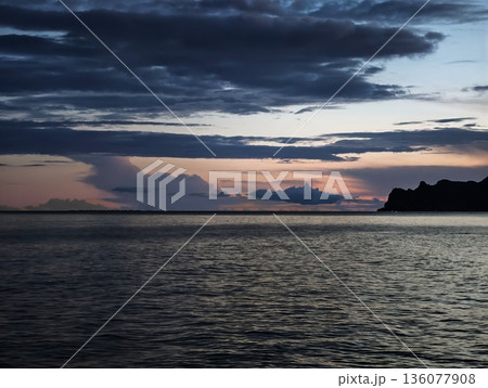 Peaceful bay under twilight sky, Silent harbor at dusk showcasing gentle waves and distant mountains Peaceful bay under twilight sky, Silent harbor at dusk showcasing gentle waves and distant mountains 136077908