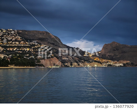 Harbor scene illuminated, Serene seaside settlement with guiding lights and tranquil mooring spot 136077920