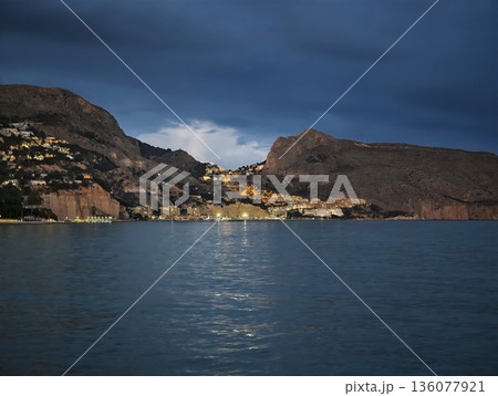 Serene dawn over rugged coast, Peaceful sunrise illuminating jagged seaside with tranquil waters 136077921
