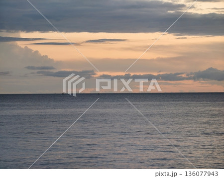 Golden light over peaceful sea, Serene sunset illuminating gentle surf and distant coastlines Golden light over peaceful sea, Serene sunset illuminating gentle surf and distant coastlines 136077943