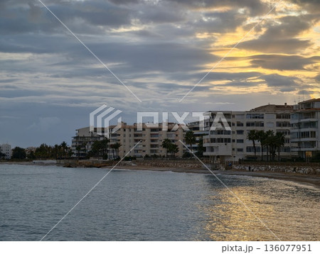Calm bay with luminous buildings, Evening at waterfront showing peaceful bay and illuminated structures 136077951